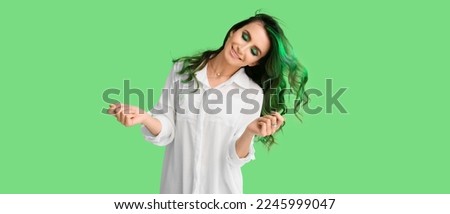 Unusual young woman with beautiful hair on green background