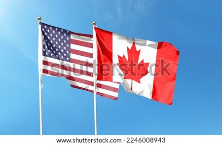 USA and Canada flags against cloudy sky. waving in the sky Royalty-Free Stock Photo #2246008943