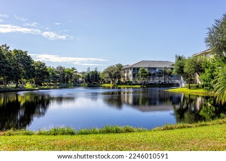 Pelican Bay Community Park in Naples, Florida Collier County near Vanderbilt Beach on sunny day with blue sky reflection in lake and green lush plants grass