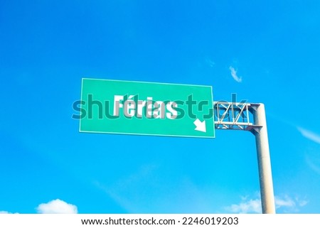 The word vacation in Brazilian Portuguese written on a green road sign.
