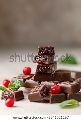 Chocolate bar with berry filling on white background. Stack of dark chocolate stuffed with berries. Chocolate concept