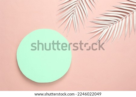 Blue circle with white palm leaves on a pink background. Minimal tropical background. Creative layout