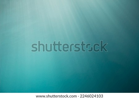 Aqua blue or turquoise background with underwater light rays shining from the sun.