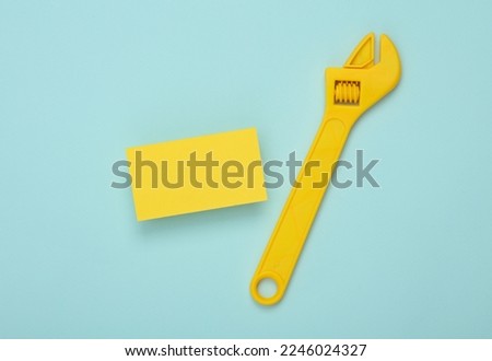 Yellow Blank business cards for branding and wrench on blue background. Creative Mockup for presentations and corporate identity.