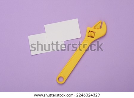 White Blank business cards for branding and wrench on purple background. Creative Mockup for presentations and corporate identity.