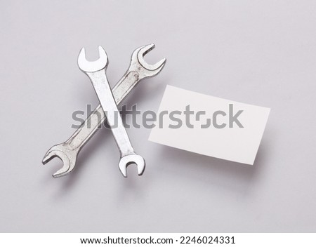 White Blank business cards for branding and wrench on gray background. Creative Mockup for presentations and corporate identity.