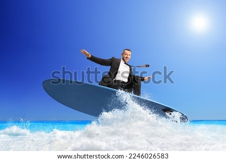 Businessman riding a surfboard on a sea wave Royalty-Free Stock Photo #2246026583