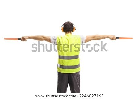 Back view of an aircraft marshaller signalling with wands isolated on white background Royalty-Free Stock Photo #2246027165