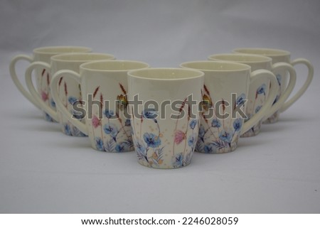 Colorful set of White Ceramic Tea or Coffee mug with Blue red flowers and butterflies on it , isolated on white background