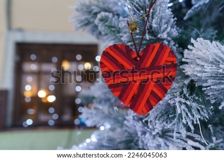 Beautiful decoration of the Christmas tree. Moscow city street in December. Blurred entrance into building. Huge bright red heart hung up on the Christmas tree. Classical romantic concept Royalty-Free Stock Photo #2246045063