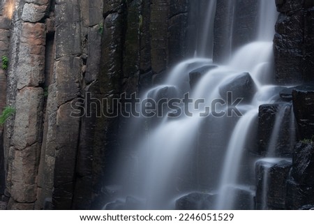 Long exposure photo of a waterfall over basaltic prisms in Hidalgo, México.
