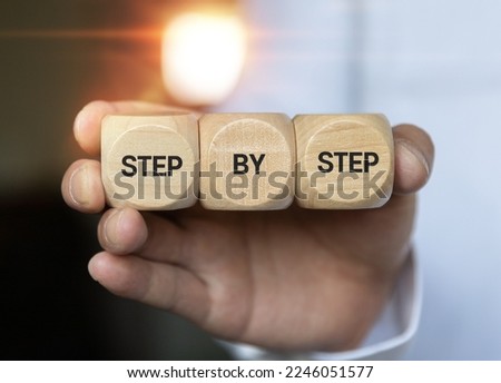 The word step by step on wooden cubes. Achievement or progress in business career.
