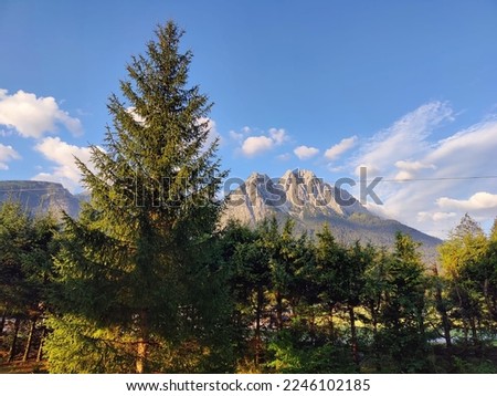 Eibsee Lake at sunrise. Turquoise water, stones, clouds, mountains and forest visible.