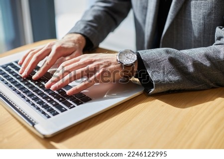 Closeup of copywriter hands using laptop computer, typing on keyboard working freelance project online, selective focus. Man searching information on website, technology concept 	