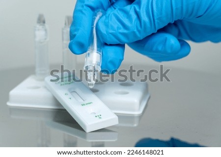 Person drops specimen test liquid in rapid test cassette for detection of Corona virus Covid-19. Personal antigen rapid self test kit for home. For in vitro diagnostic use only. Royalty-Free Stock Photo #2246148021