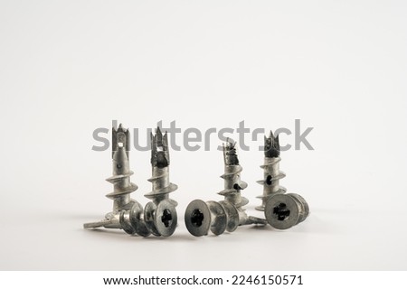 close up of metal galvanised wall plug anchors with screw thread and cross head screw isolated on a white background