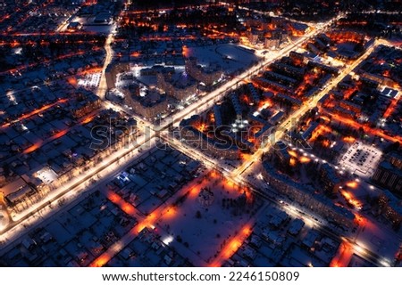 Night winter city with illuminated streets. Cityscape, drone view.