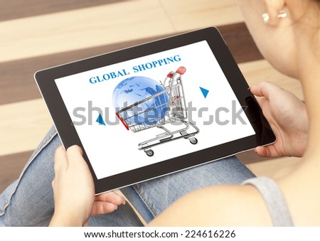 Woman using laptop with online global shopping cart on screen