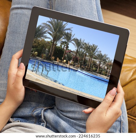 Cropped image of woman looking at resort photo on tablet