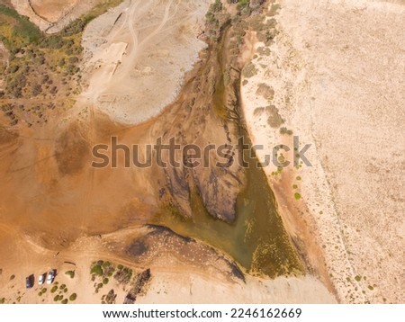 Dry riverbed with couple of palms and desert plants around it. Only source of water and life during the drough. Boa Vista rough nature during summer. Drone image from around 100m up in the air