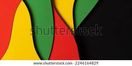 Black History Month color background. Abstract paper cut style composition with layers of geometric shapes and wavy lines in red, yellow, green colors