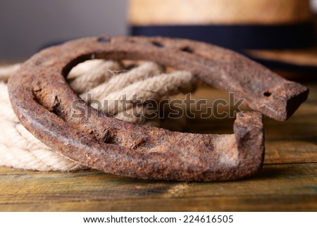 American West still life with old horseshoe, hat and cowboy lasso, on grey background