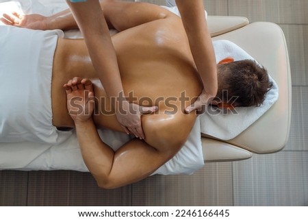 Sports man massage in a light room, procedure in a fitness center Royalty-Free Stock Photo #2246166445