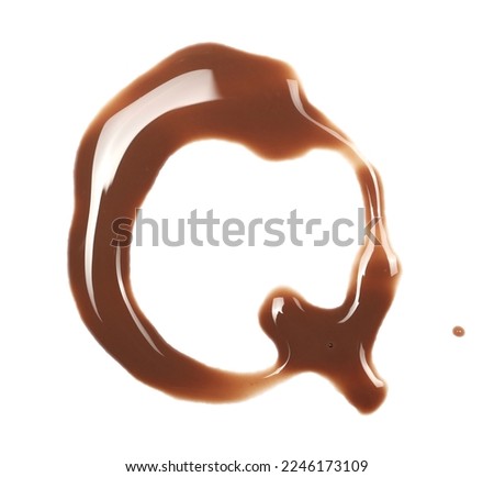 Spilled chocolate milk puddle in shape letter Q isolated on white background, top view