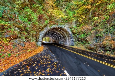 A landmark Smoky Mountains tunnel, which lies between Townsend, Tennessee and Cades Cove,  is surrounded by a show of Autumn colors. Royalty-Free Stock Photo #2246177213