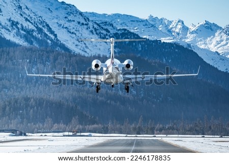 Business jet landing at the alpine airport in Samedan in the engadin valley in the Swiss alps. The luxurious way to travel to the world famous winter ski resort. The way rich people travel.  Royalty-Free Stock Photo #2246178835
