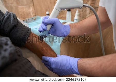 Medical specialist performing non-invasive surgical pain redduction Royalty-Free Stock Photo #2246192107