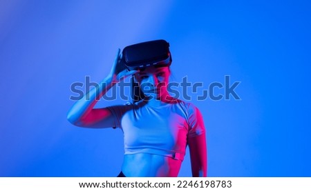 Portrait of brunette woman getting experience in metaverse using VR headset glasses. Exploring a cyberspace via virtual reality.