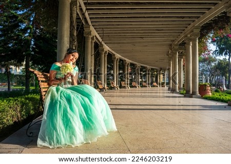 Beautiful woman dressed in a princess costume sitting on a columned passageway of a palace, space for text