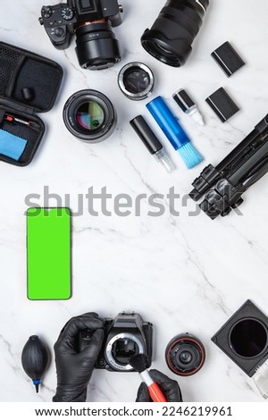 Layout of cleaning workstation for digital cameras with mobile phone with green screen chroma key. Vertical view of modern white marble desk