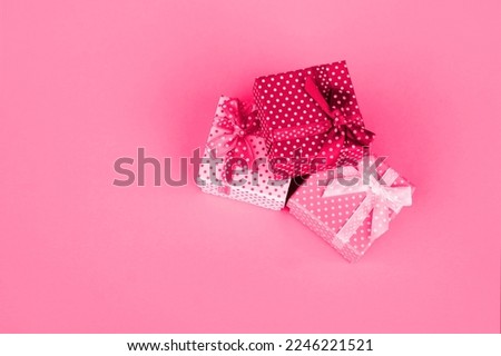 Three gifts on a pink background. Image toned in Viva Magenta, color of the 2023 year.