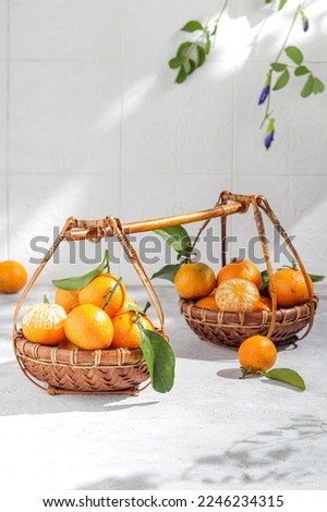 Tangerinea  fruits or Santang in traditional bamboo basket. Oranges and Tangerines bring luck and happiness. Royalty-Free Stock Photo #2246234315