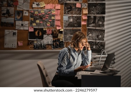 Woman looking at laptop screen in police office calling to colleague. Detective analyzing data and discussing criminal case in agency office. Copy space