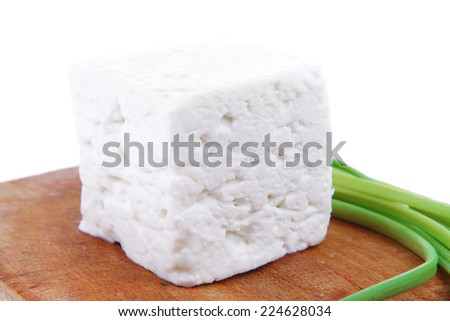 diet food : greek feta white cheese served on wooden plate isolated over white background