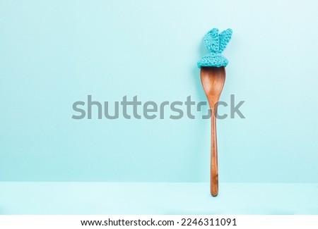 Blank paper with a wooden spoon and easter bunny ears, spring holiday greeting card, copy space for a recipe 