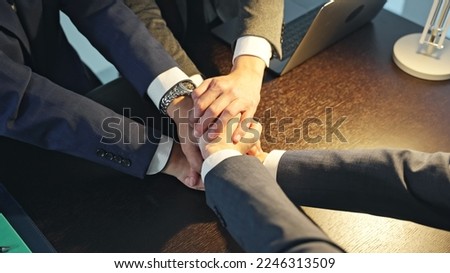 Business people forming a circle in a dark office.