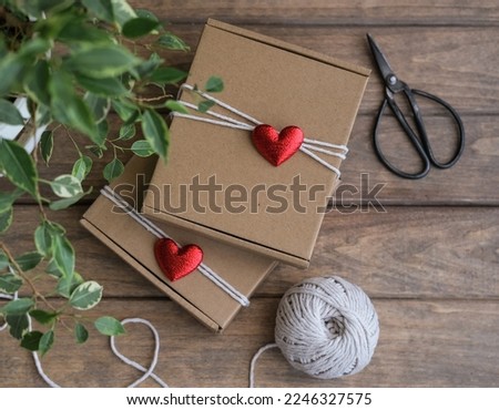 Valentine's Day gift wrapping. Kraft gift boxes decorated with red hearts Royalty-Free Stock Photo #2246327575