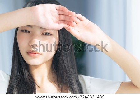 Young Asian woman in the sun. Skin care. UV care. Sunscreen. Royalty-Free Stock Photo #2246331485
