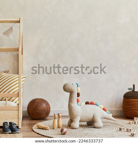 Stylish composition of cozy scandinavian child's room interior with wooden bed, plush and wooden toys and textile hanging decorations. Creative wall, carpet on the floor. Copy space. Template Royalty-Free Stock Photo #2246333737