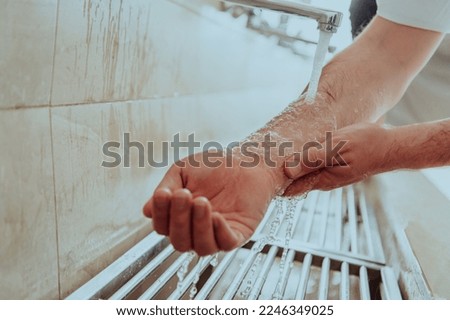 A Muslim performing ablution. Ritual religious cleansing of Muslims before performing prayer. The process of cleansing the body before prayer Royalty-Free Stock Photo #2246349025