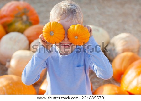 active little boy having fun at pumpkin patch