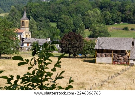 View at Moulis village at Ariege, Occitanie region of France in Pyrenees mountains. On the picture  we can see a field with the barn and Moulis church on the background.