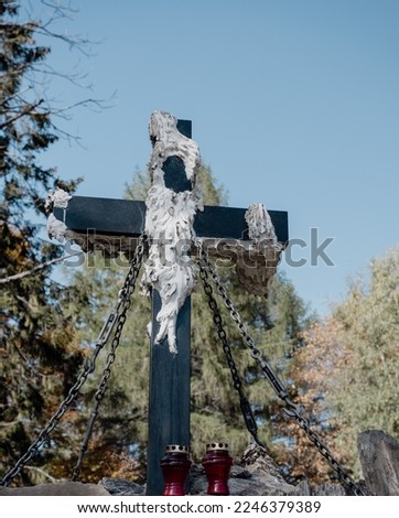 Christian cross with chains against the background of the forest and sky with candles