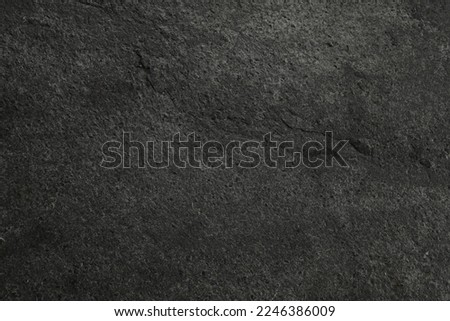 Texture of dark grey stone surface as background, closeup