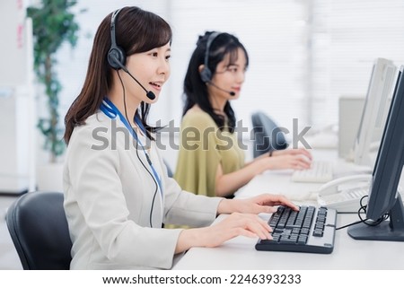 A woman responding to a customer at a call center Royalty-Free Stock Photo #2246393233