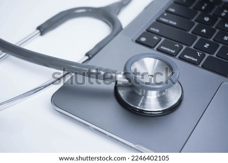 grey Stethoscope on laptop or on the keyboard of pc, close-up. macro view of a grey stethoscope on a business office laptop keyboard with selective focusing effect
